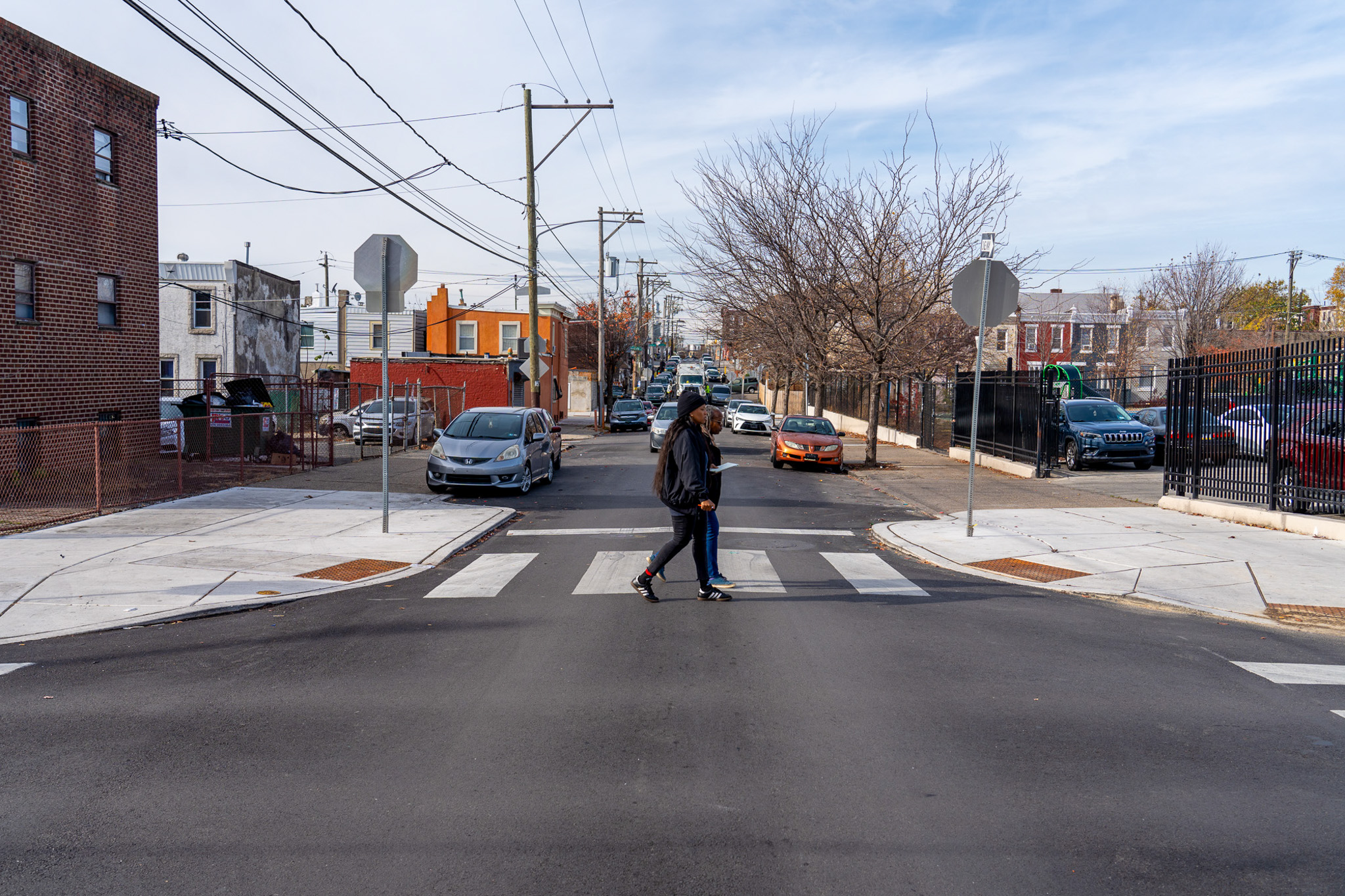 Image of two people crossing the street in a crosswalk.