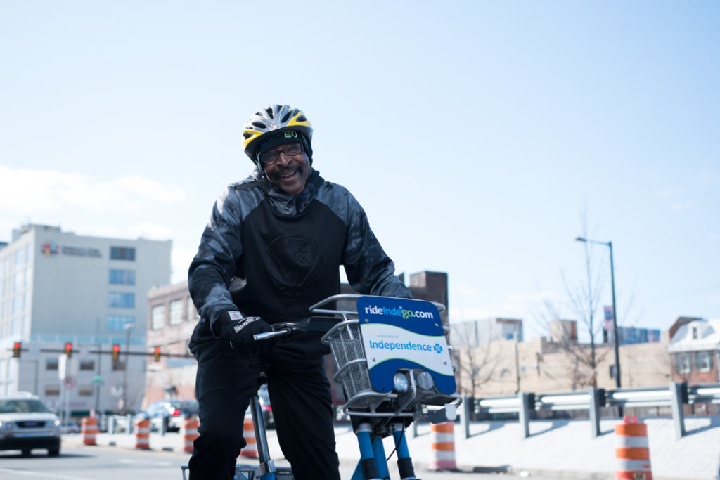 Image of Alan Lomax posing on an Indego bicycle. 